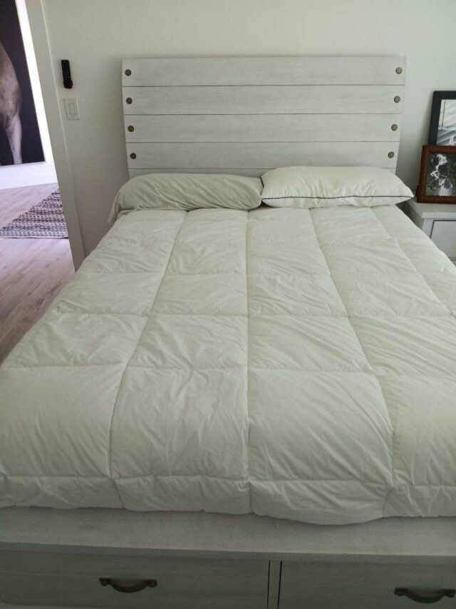 Neatly made bed with white bedding